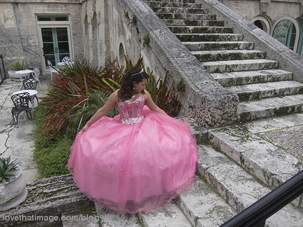 Girl in pink dress poses on steps at Vizcaya in Florida